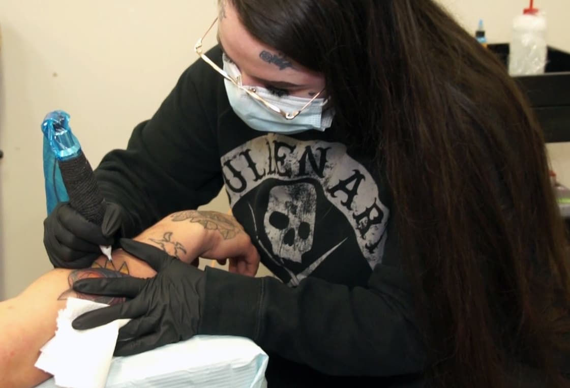 Tia Lovett au travail dans son studio de tatouage