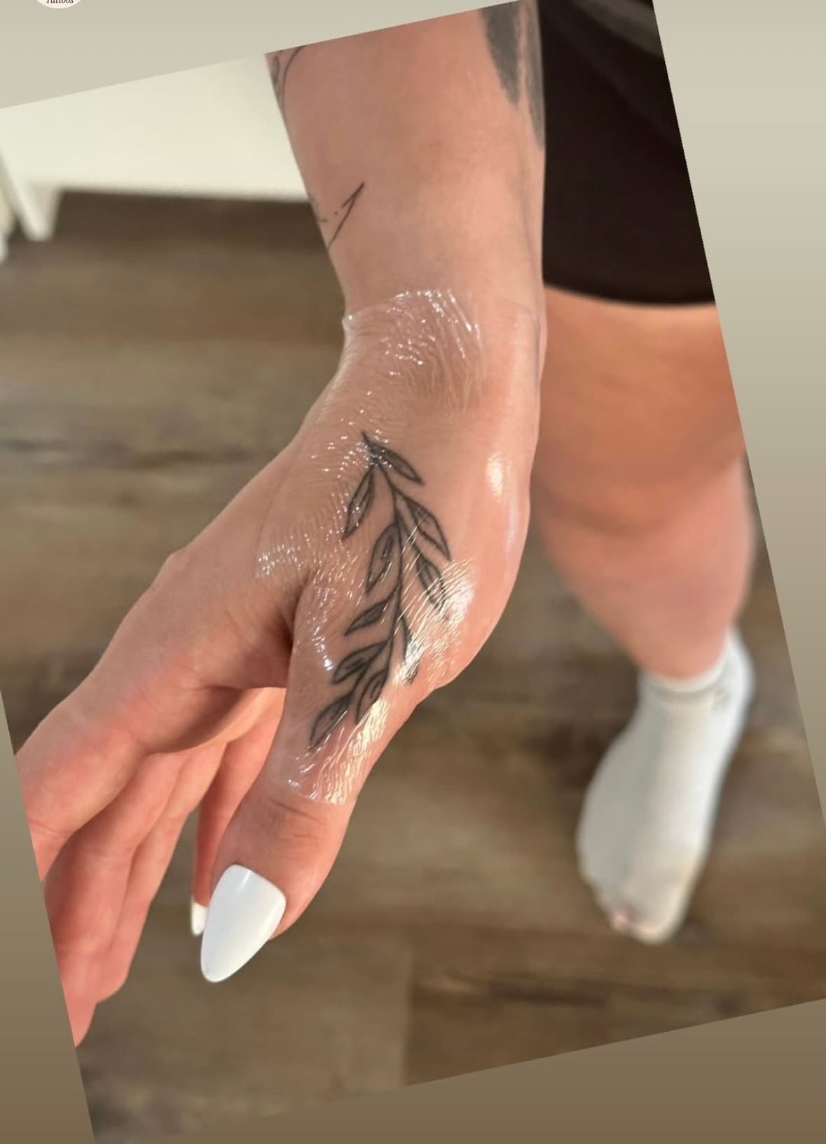 Leafy branch tattooed on top of thumb