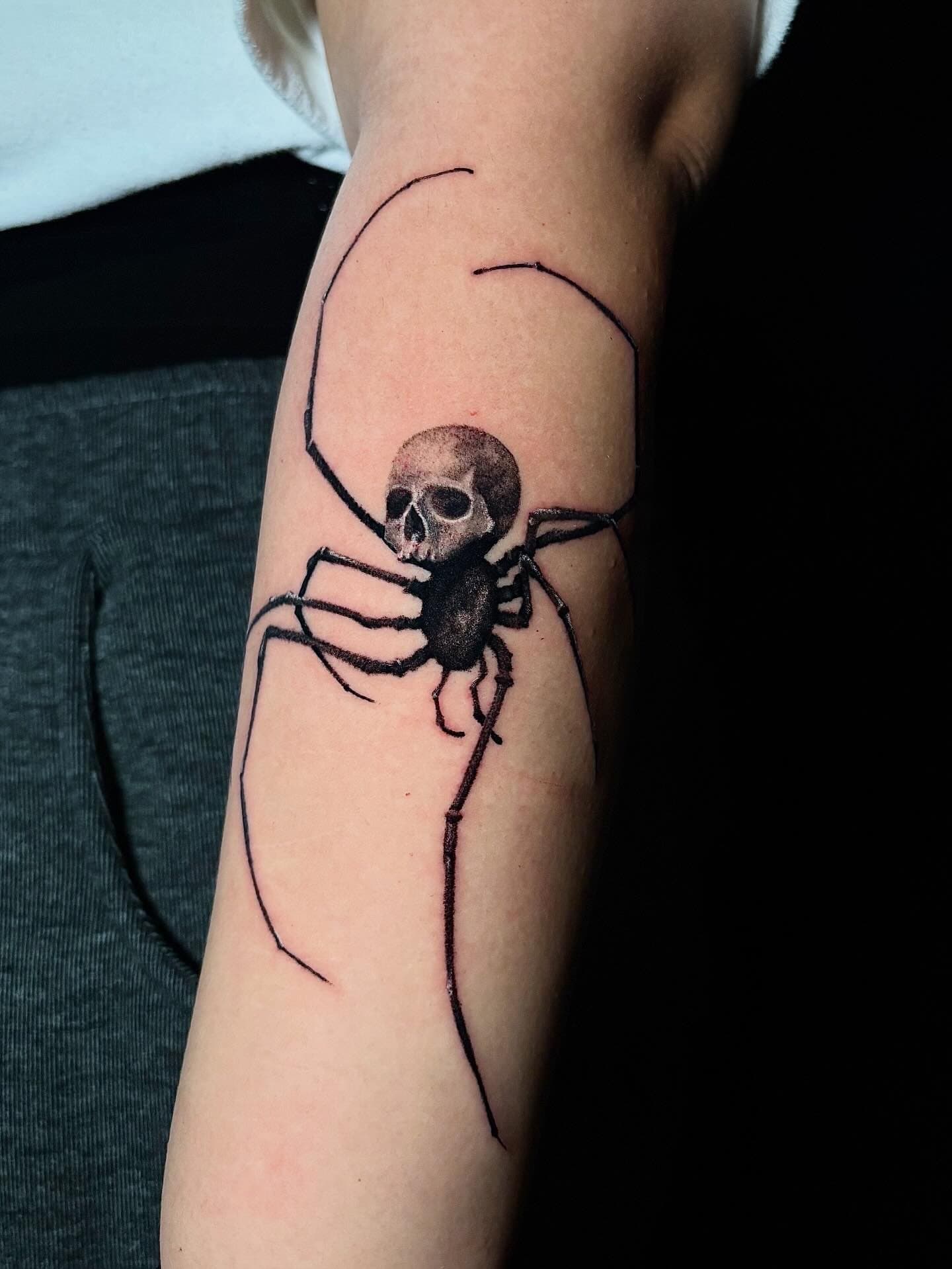 Tattoo of a spider with a skull face on a person's arm. Surrealism Tattoo Done by Pablo at Ink Terminal Ottawa Gatineau