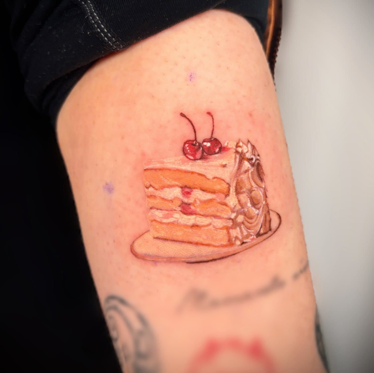 Colourful layered cake-slice tattoo topped with cherries