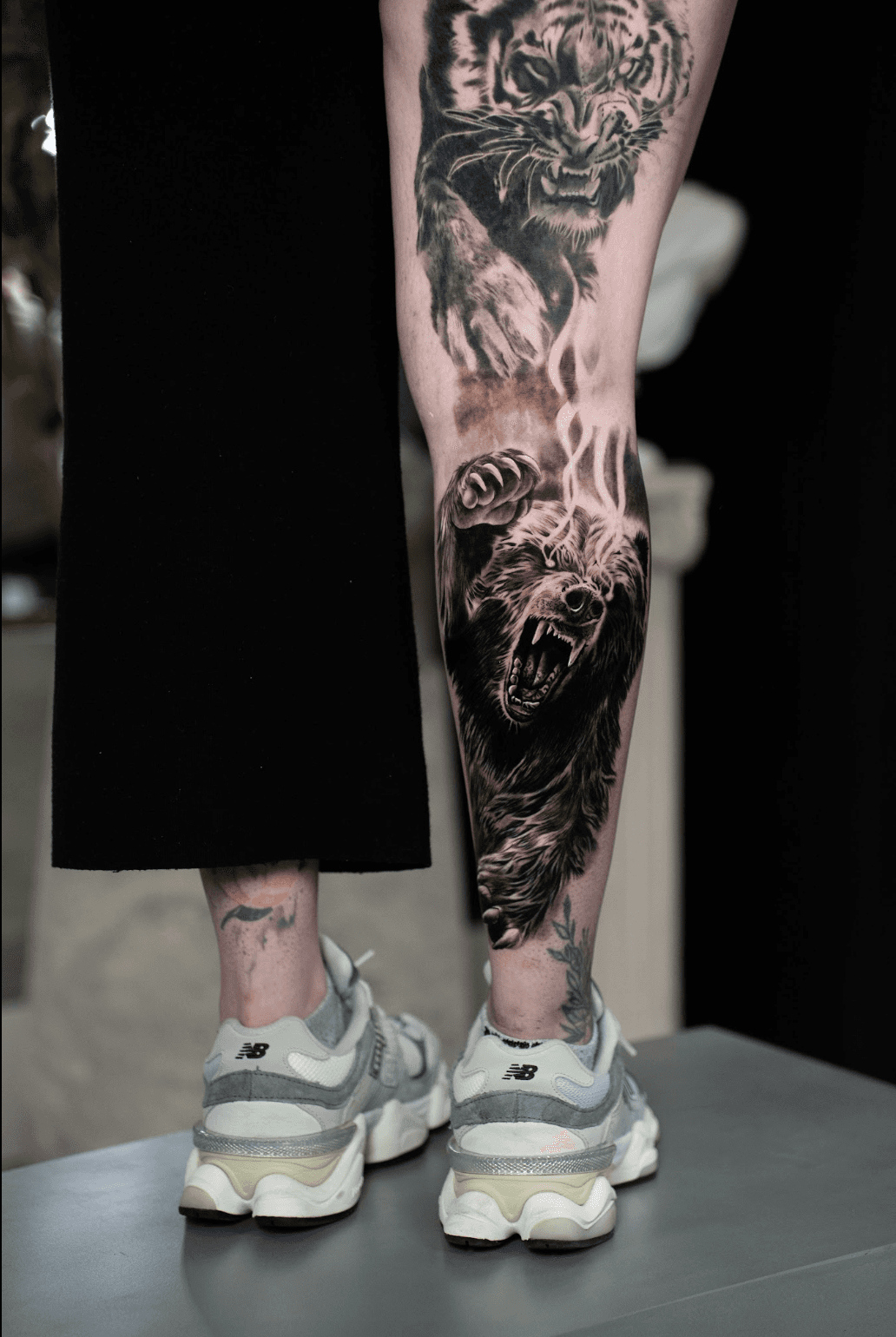 Black and grey realism leg sleeve tattoo by Luis Fernandez, Zen Tattoo Studio Oakville. Photorealistic wildlife piece featuring tiger and bear — large scale ani