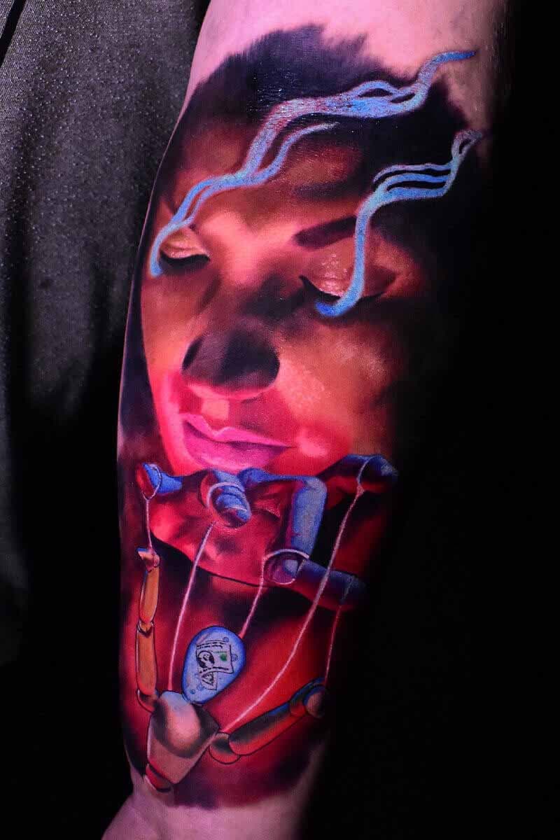 Atticus Tattoo| Colour realism tattoo of a woman with a string puppet