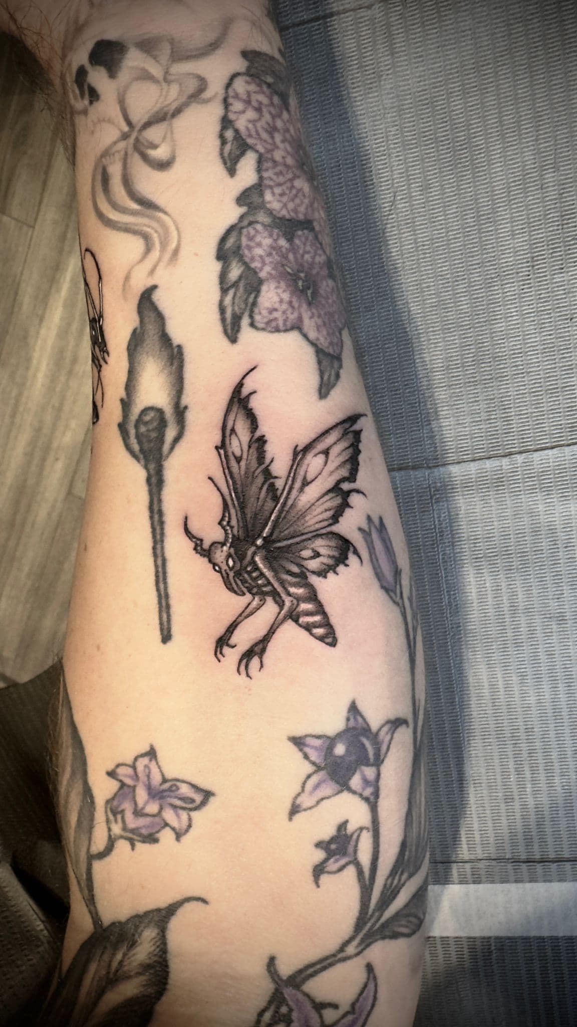 black and grey illustrative moth tattoo on arm done in toronto