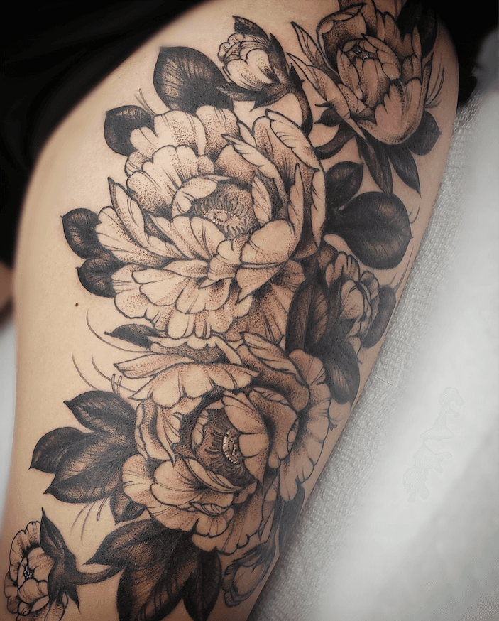 A detailed black and gray tattoo of peony flowers and leaves on a person's arm.