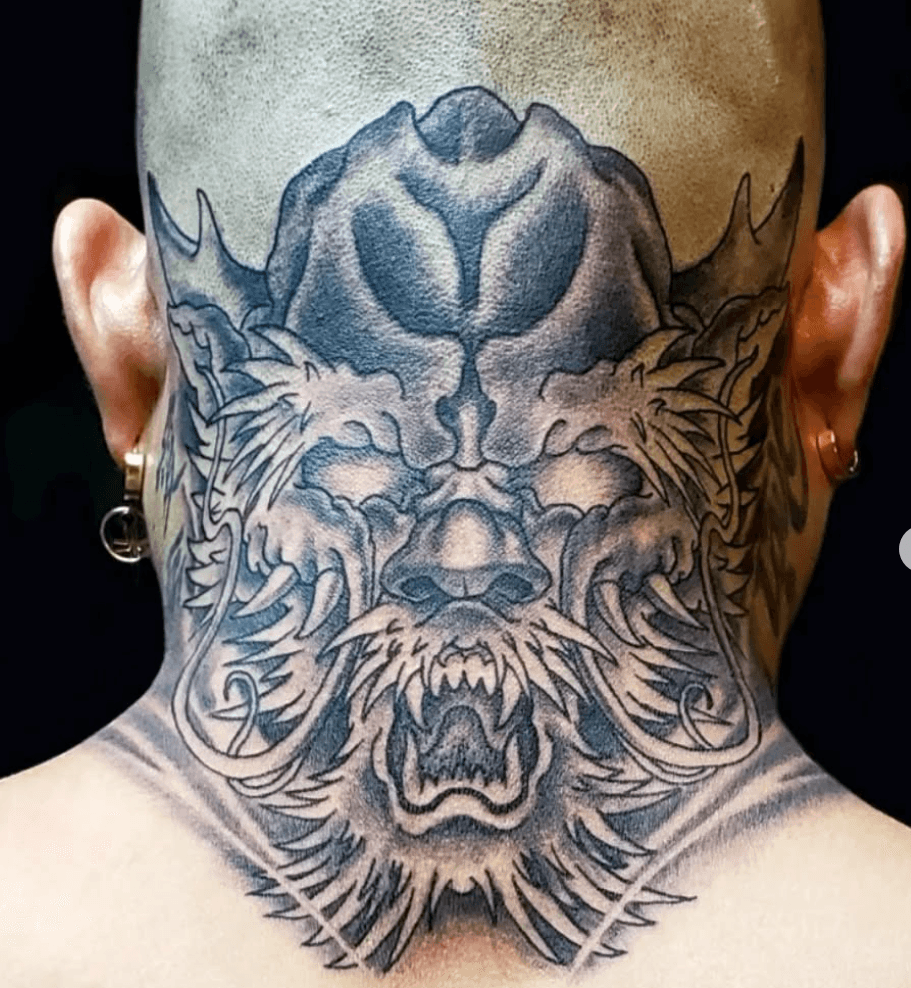 Tattoo of a fierce lion's face on the person's neck, detailed with bold lines and shading.