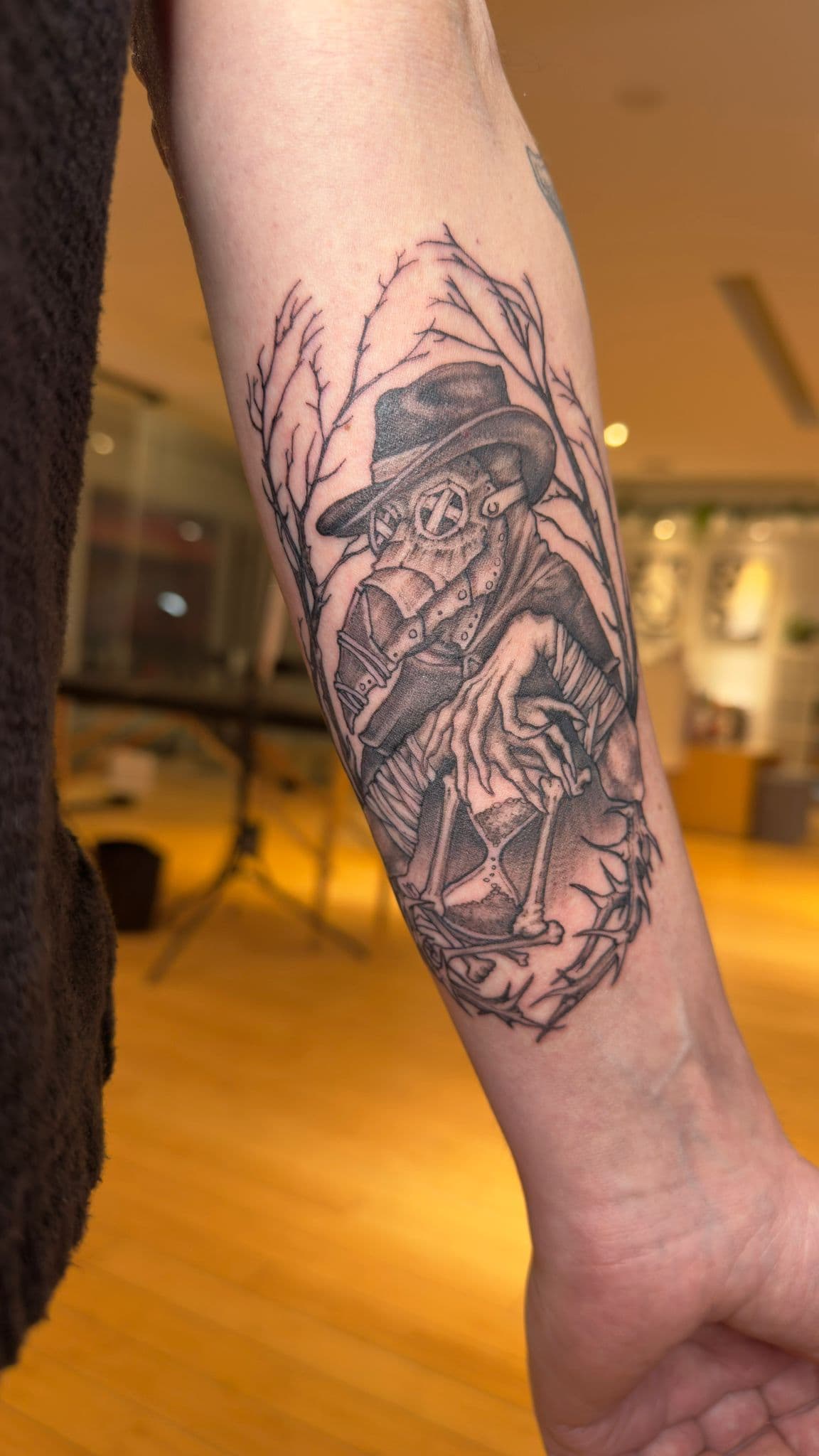 black and grey illustrative plague doctor tattoo on arm done in toronto