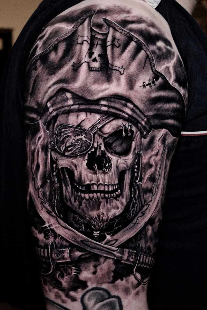 Atticus Tattoo| Black and grey realism tattoo of a skull pirate with swords
