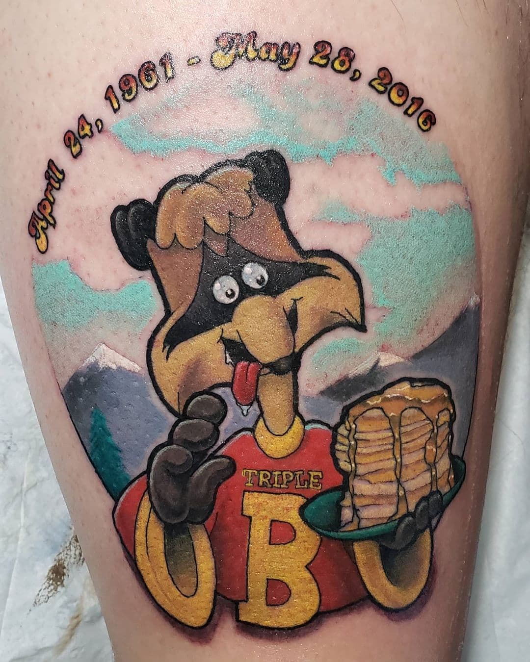 Memorial tattoo featuring Bert from Raccoons (19080's cartoon) holding a stack of pancakes.