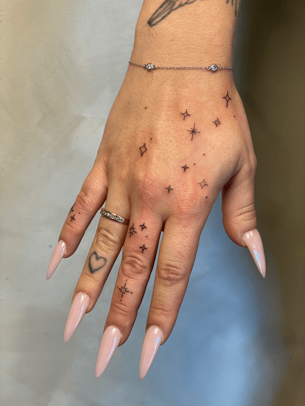 leaves, letters and fine line tattoos on wrist and fingers done by Tasha from Ink & Skin Studio.