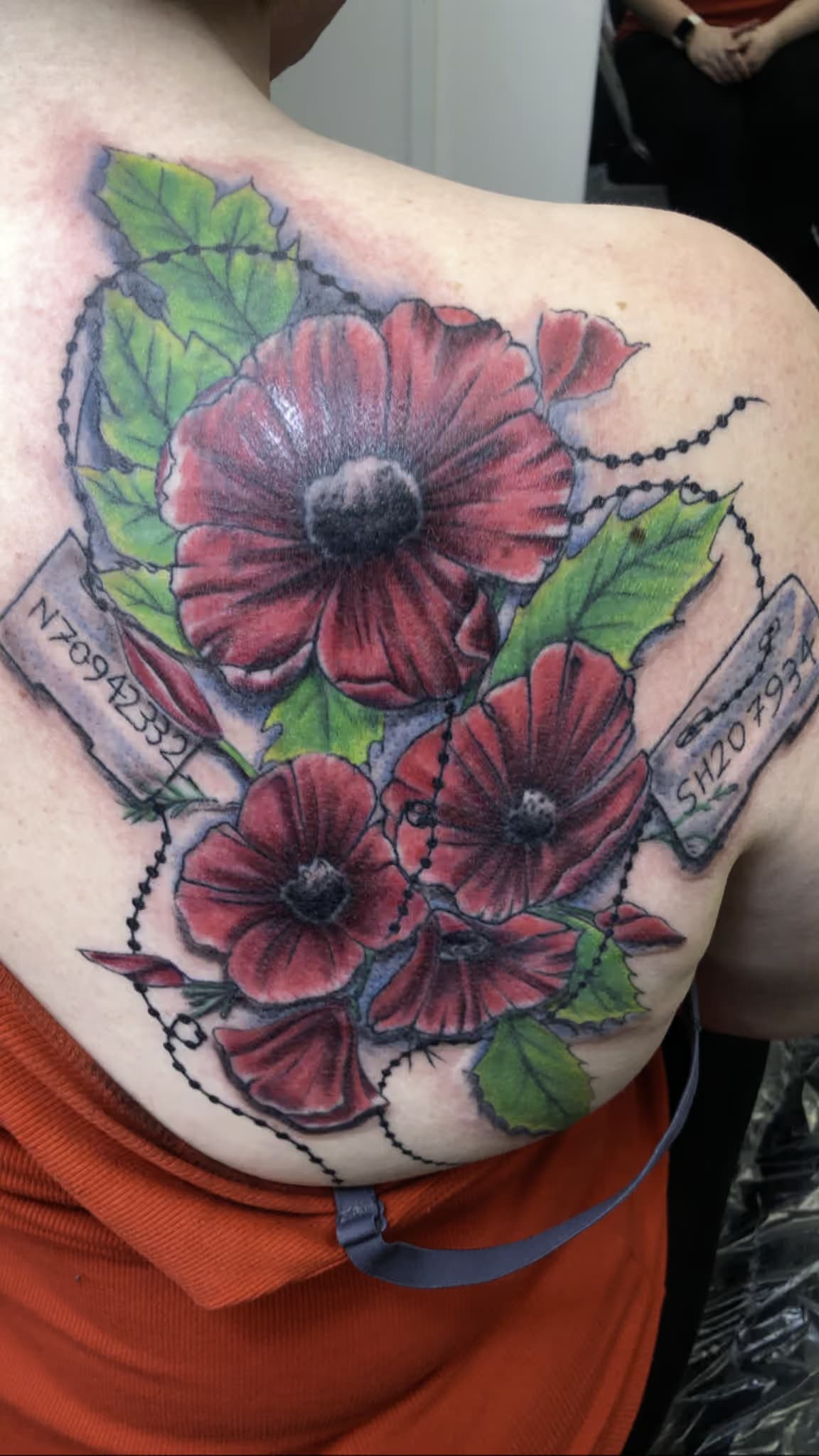 a red flower with a code number on the back of a girl in orange, made by bear.