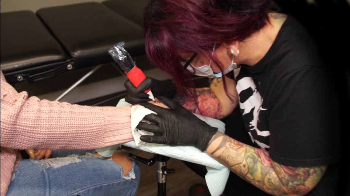 Shyloe Dy au travail dans son studio de tatouage