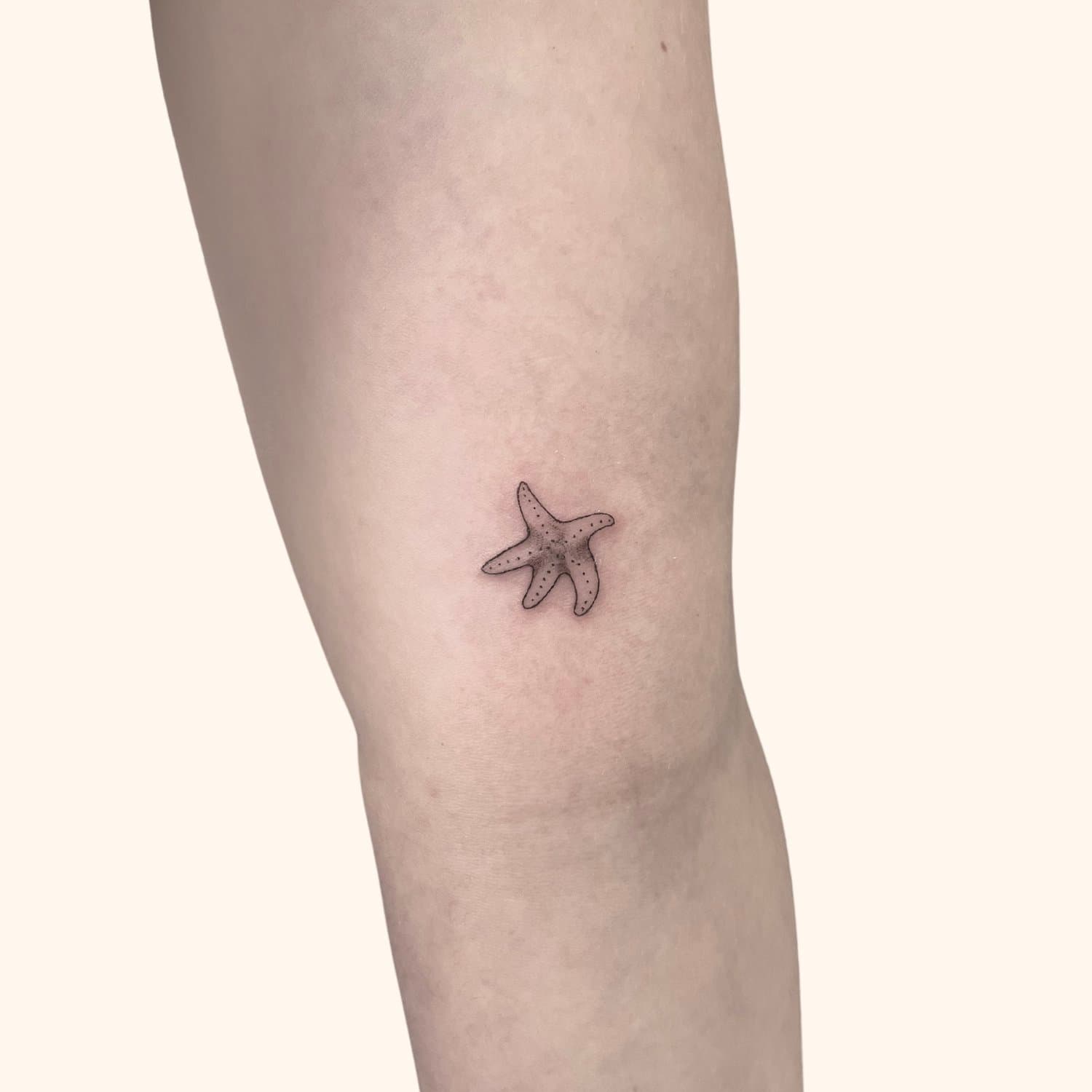 Tattoo of a starfish on a person's leg.