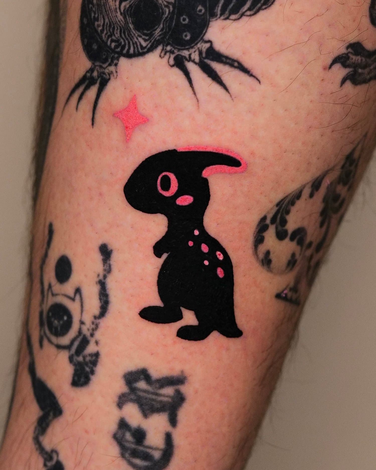 Black dinosaur character with a pink eye and pink sparkle accents