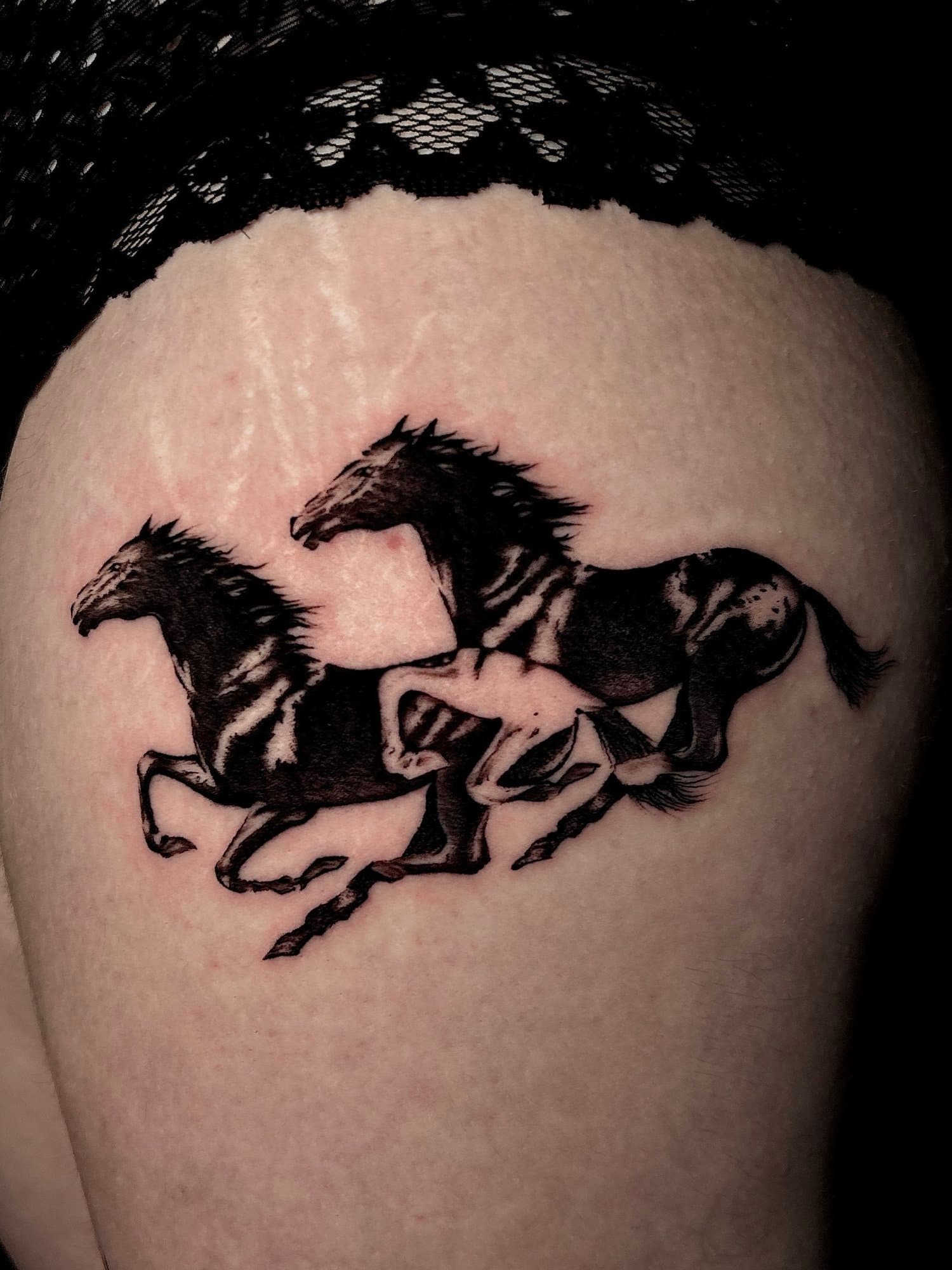 Tattoo of two black horses with manes running, on a person's skin, Surrealism Tattoo Done by Pablo at Ink Terminal Ottawa Gatineau