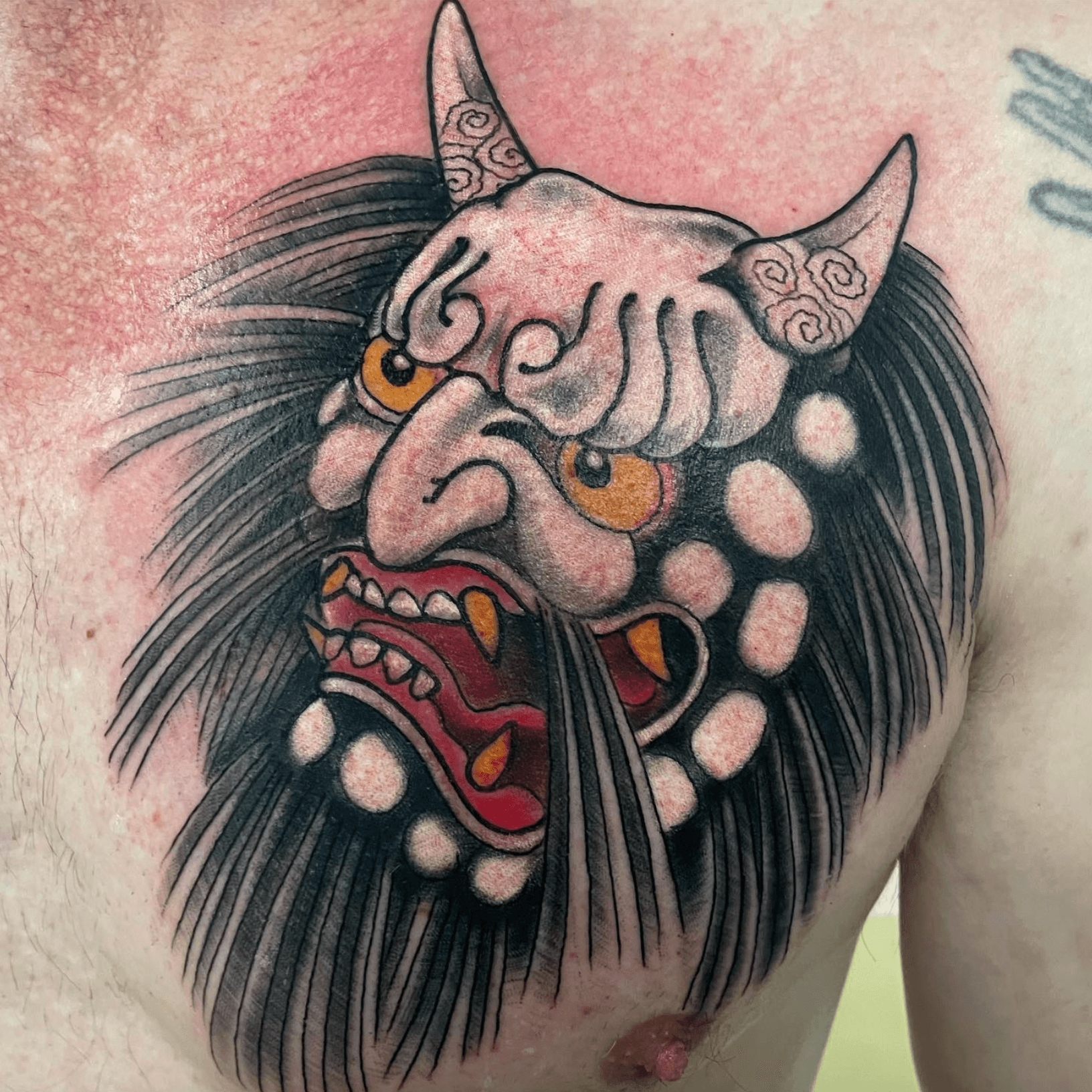 Japanese-style hannya mask chest tattoo with black hair, red mouth and orange eyes, published as the artists-hub tile linking to the Shawn Hedley profile